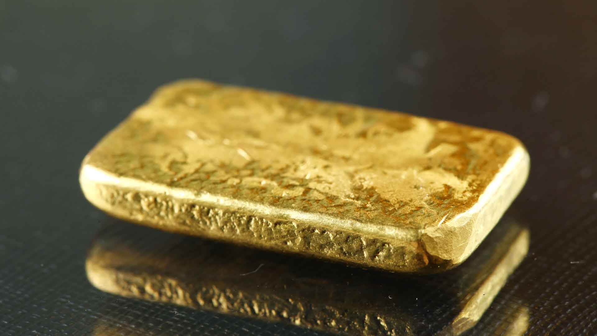 Close-up of a hand-poured gold bar with rustic texture